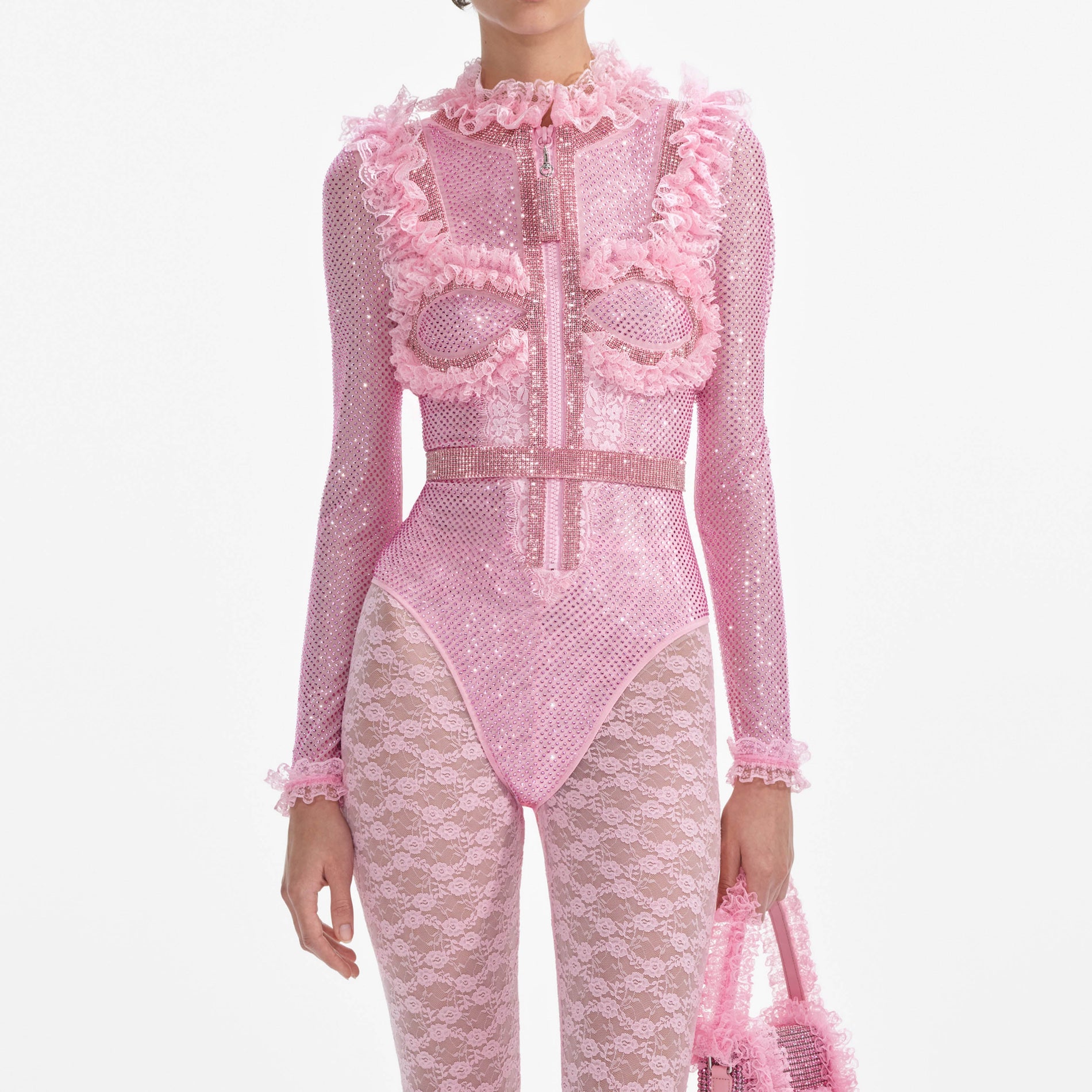 A close up of a woman wearing the Pink Rhinestone Mesh Ruffle Bodysuit