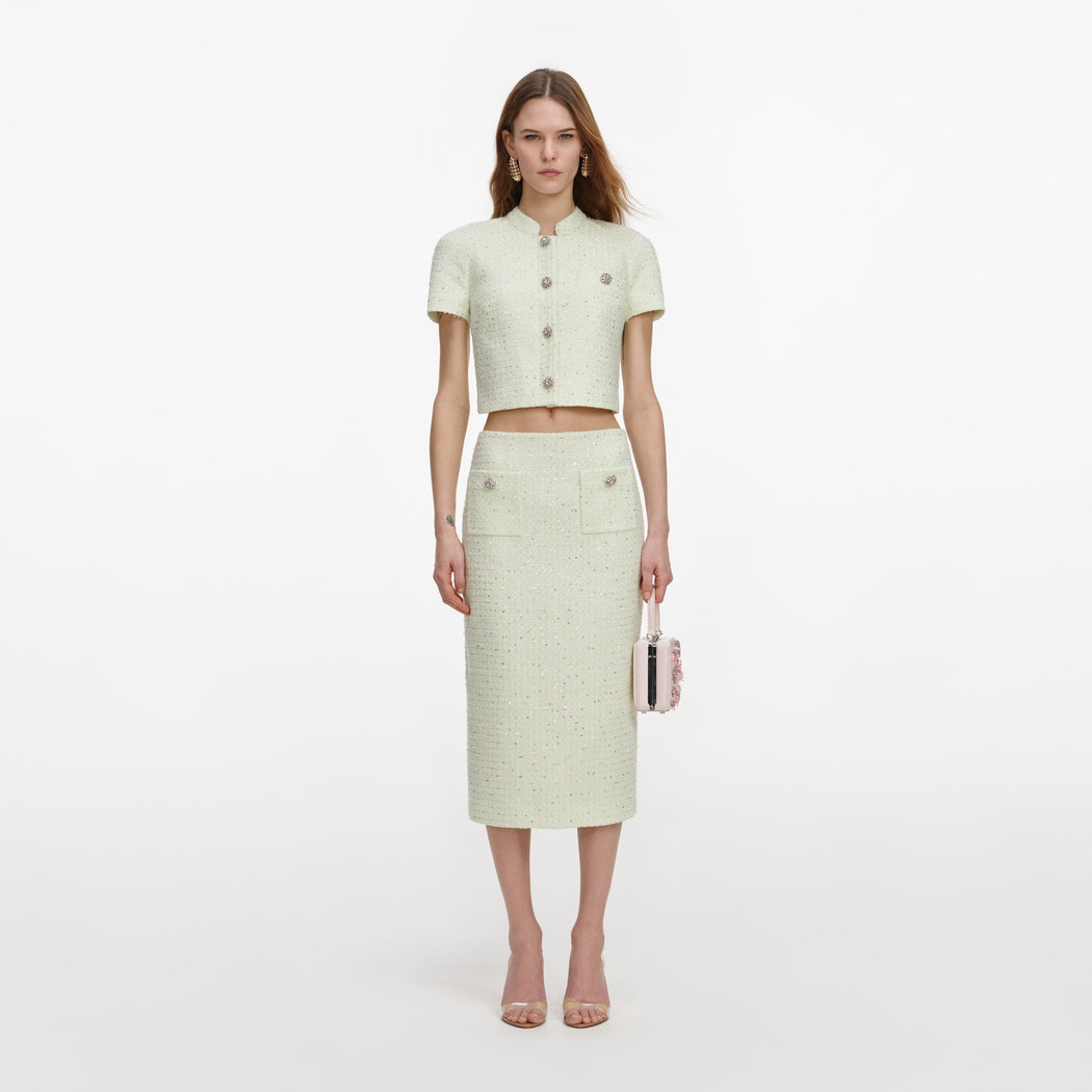 A close up of a woman wearing the Lime Boucle Midi Skirt
