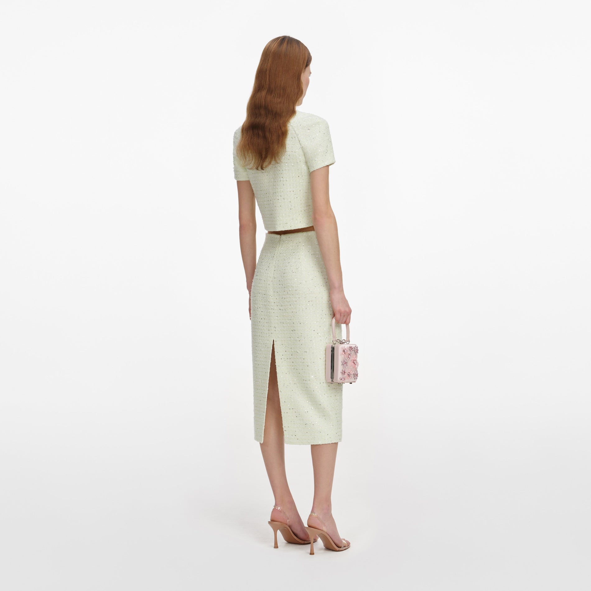 Back view of a woman wearing the Lime Boucle Midi Skirt