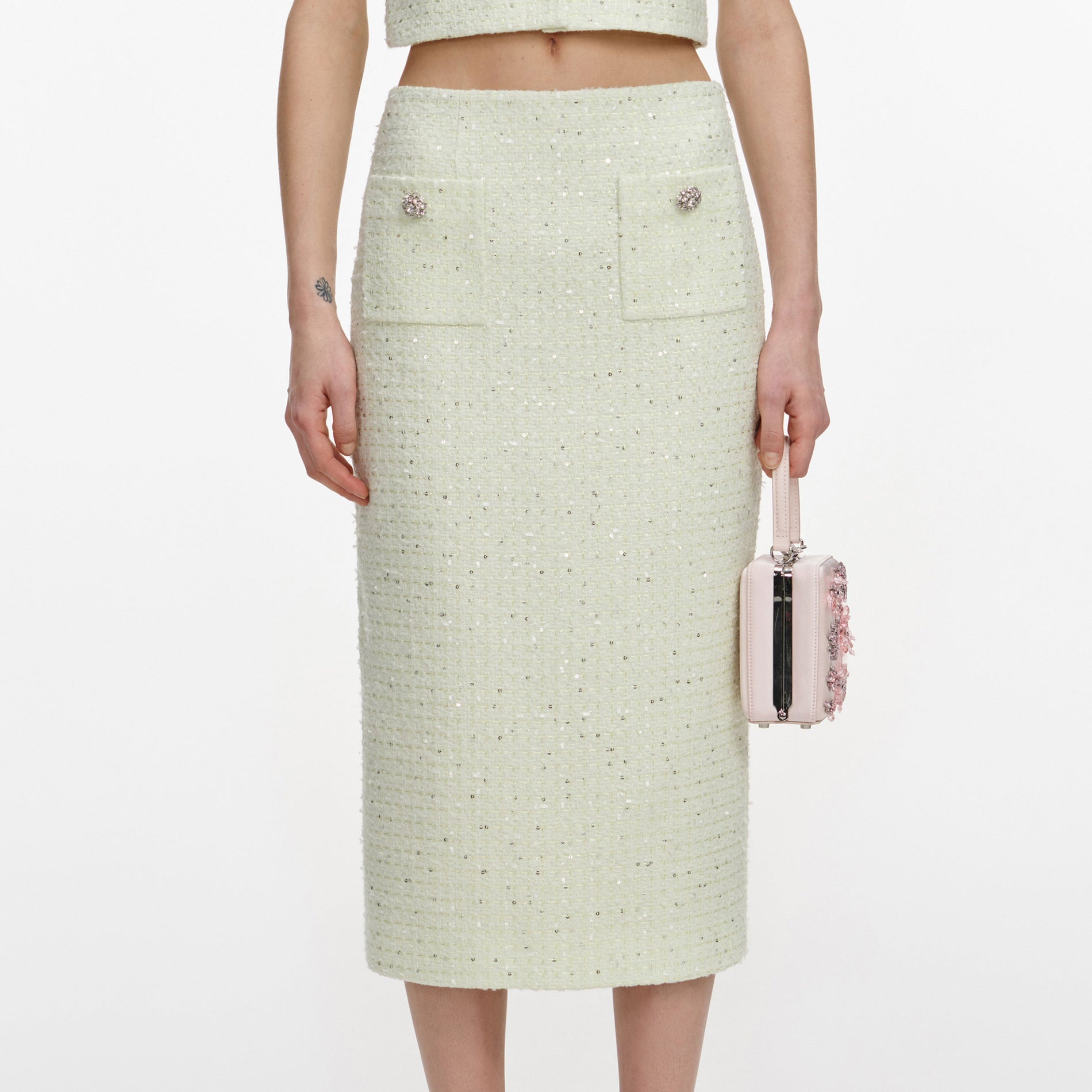 A close up of a woman wearing the Lime Boucle Midi Skirt