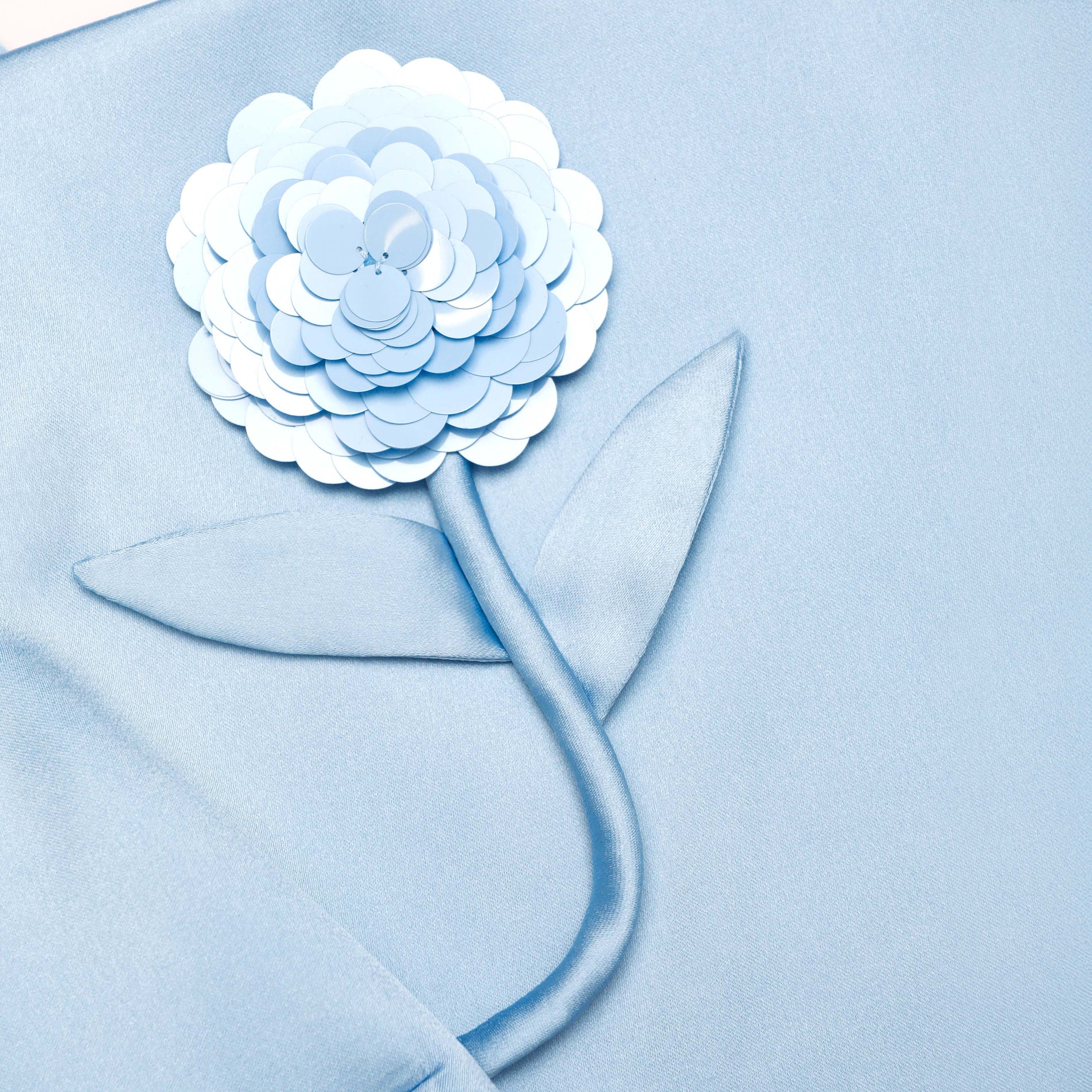 A close up of the fabric for the Blue Satin 3D Sequin Flower Top