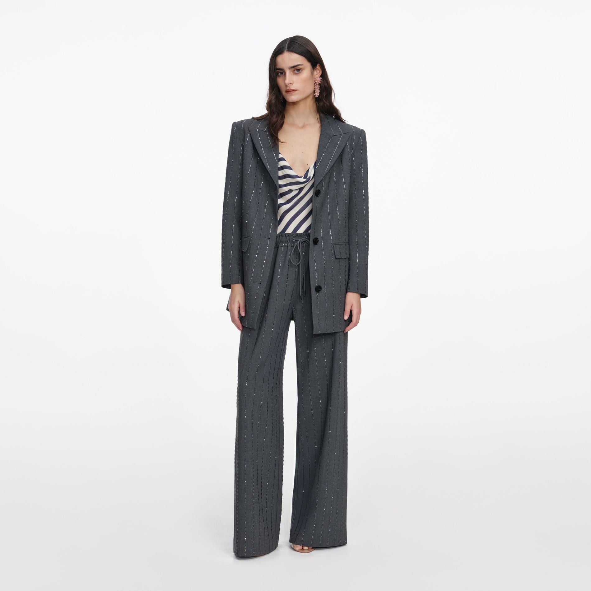 A close up of a woman wearing the Grey Rhinestone Pinstripe Blazer