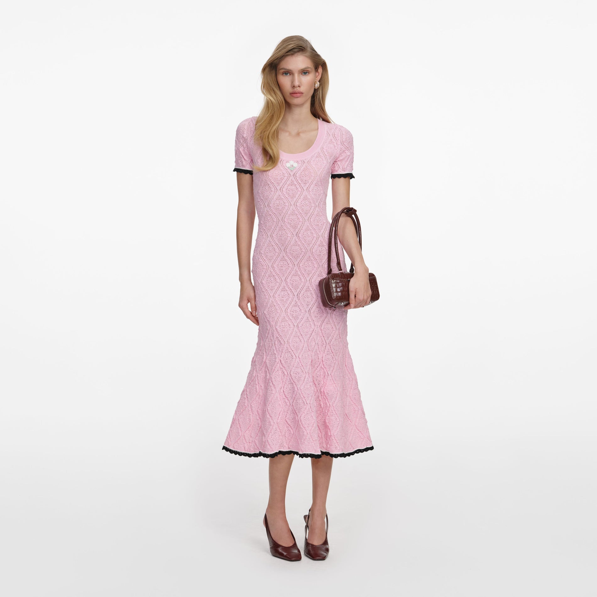 Front view of a woman wearing the Pink Pointelle Knit Midi Dress