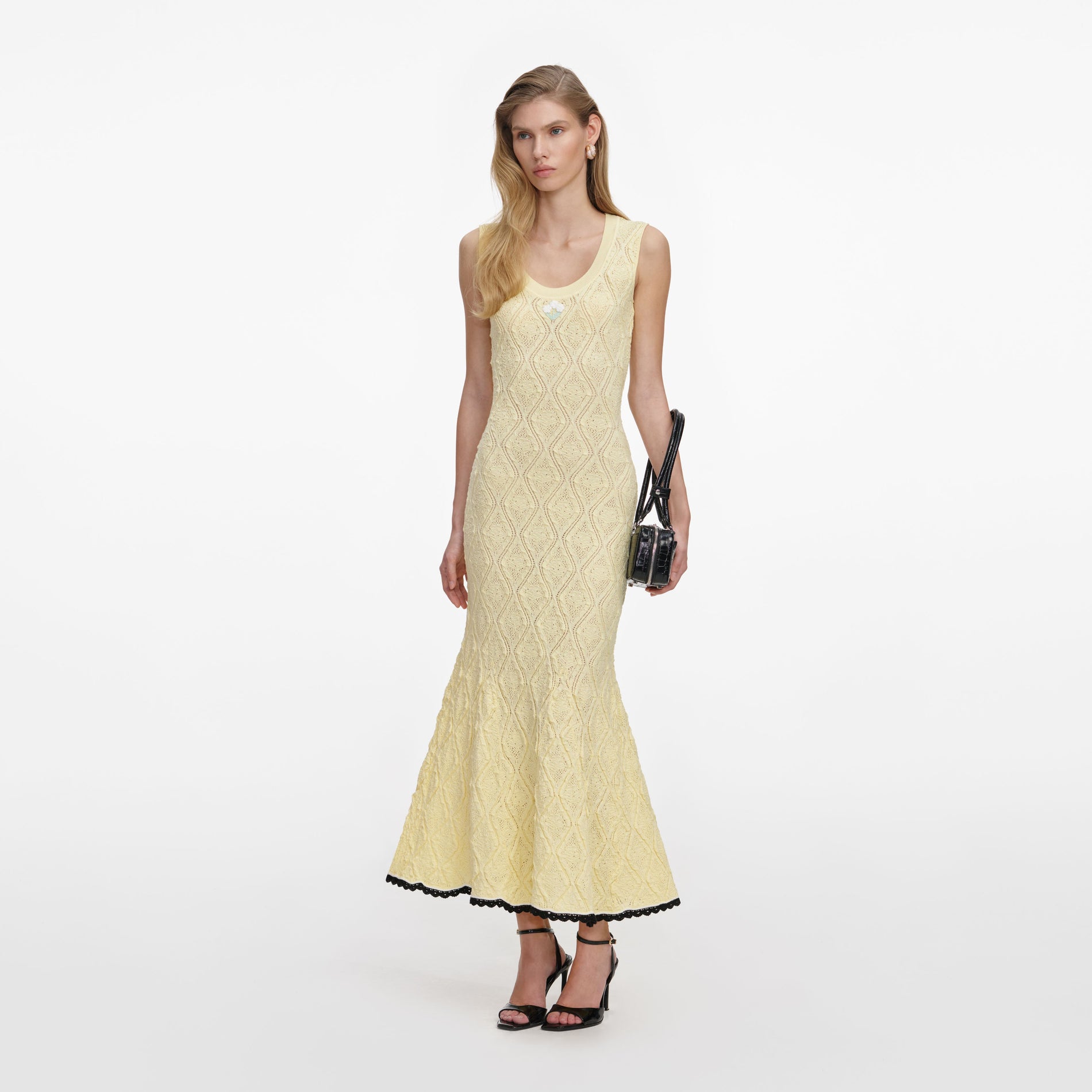 Side view of a woman wearing the Yellow Pointelle Knit Midi Dress