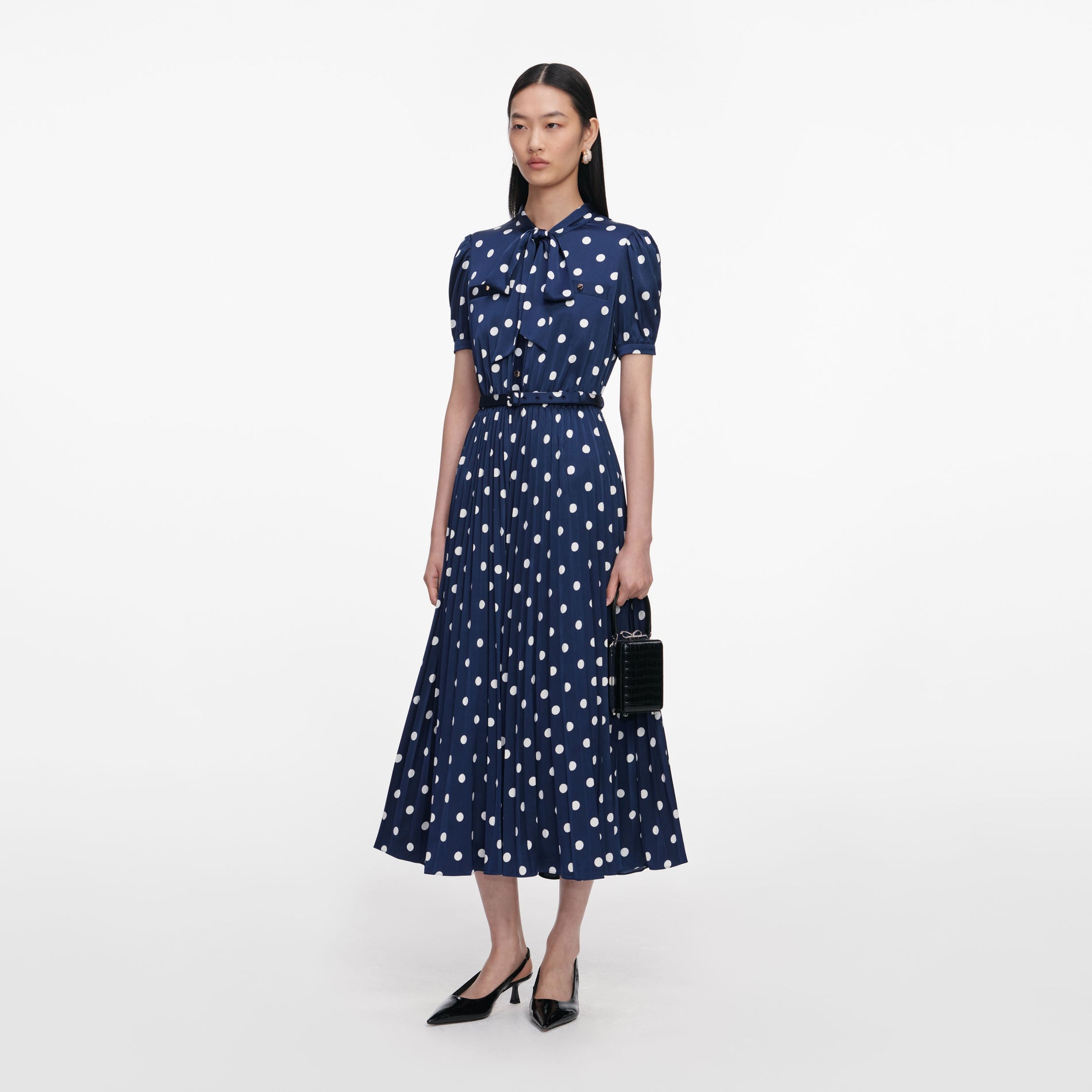 Side view of a woman wearing the Navy Polka Dot Satin Midi Dress