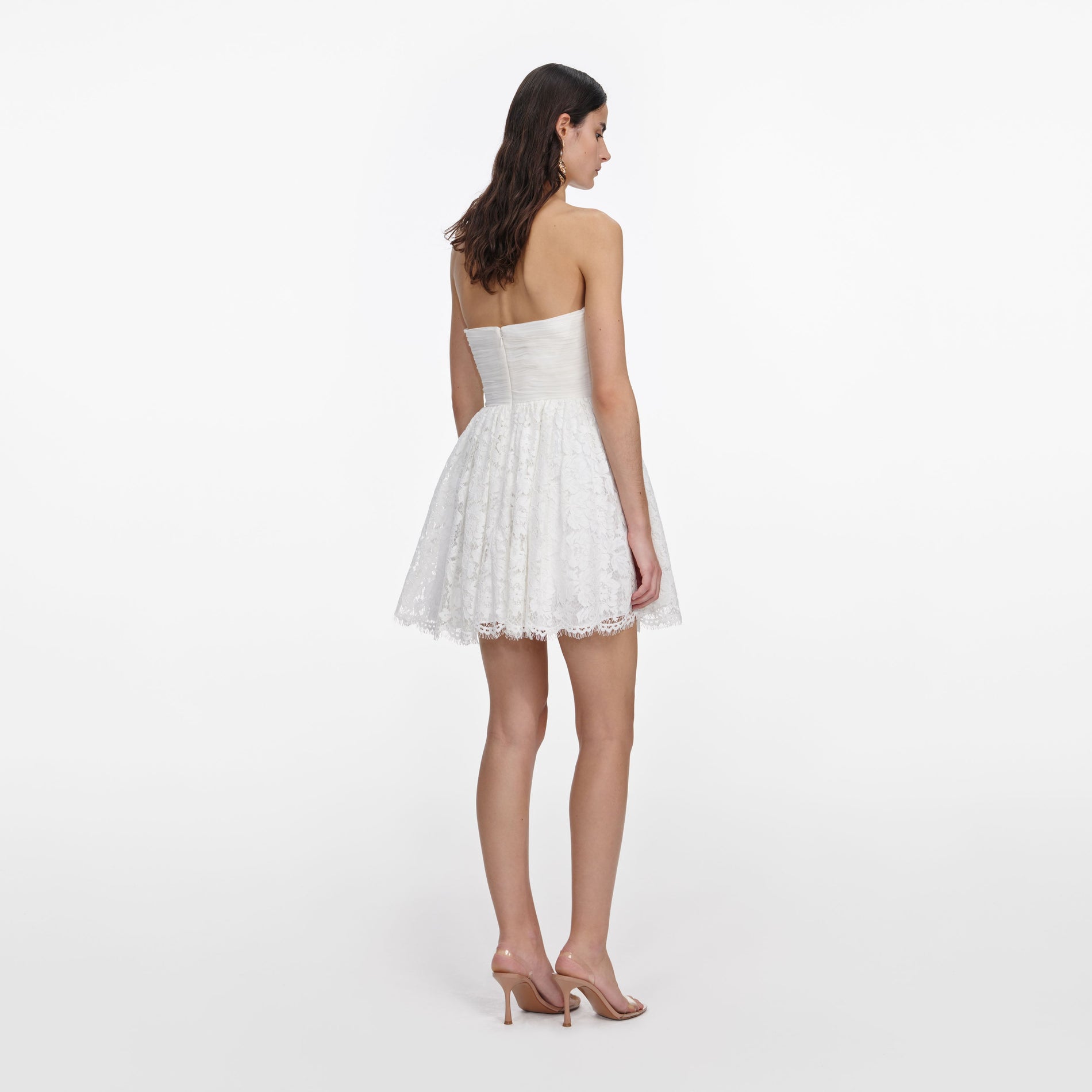 Back view of a woman wearing the White Lace Bow Mini Dress