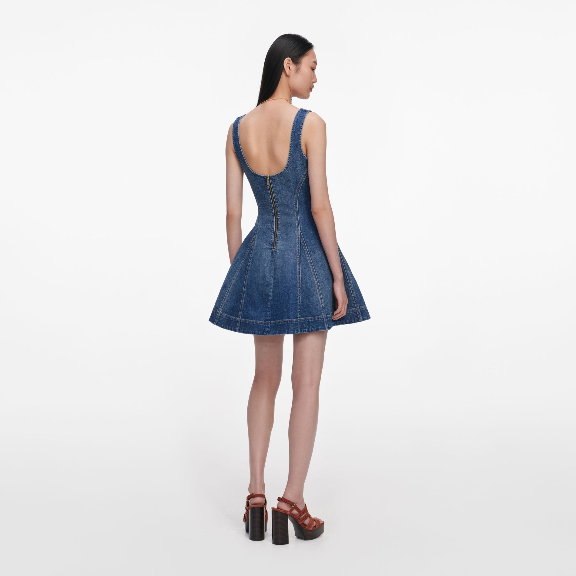 Back view of a woman wearing the Denim Flared Mini Dress