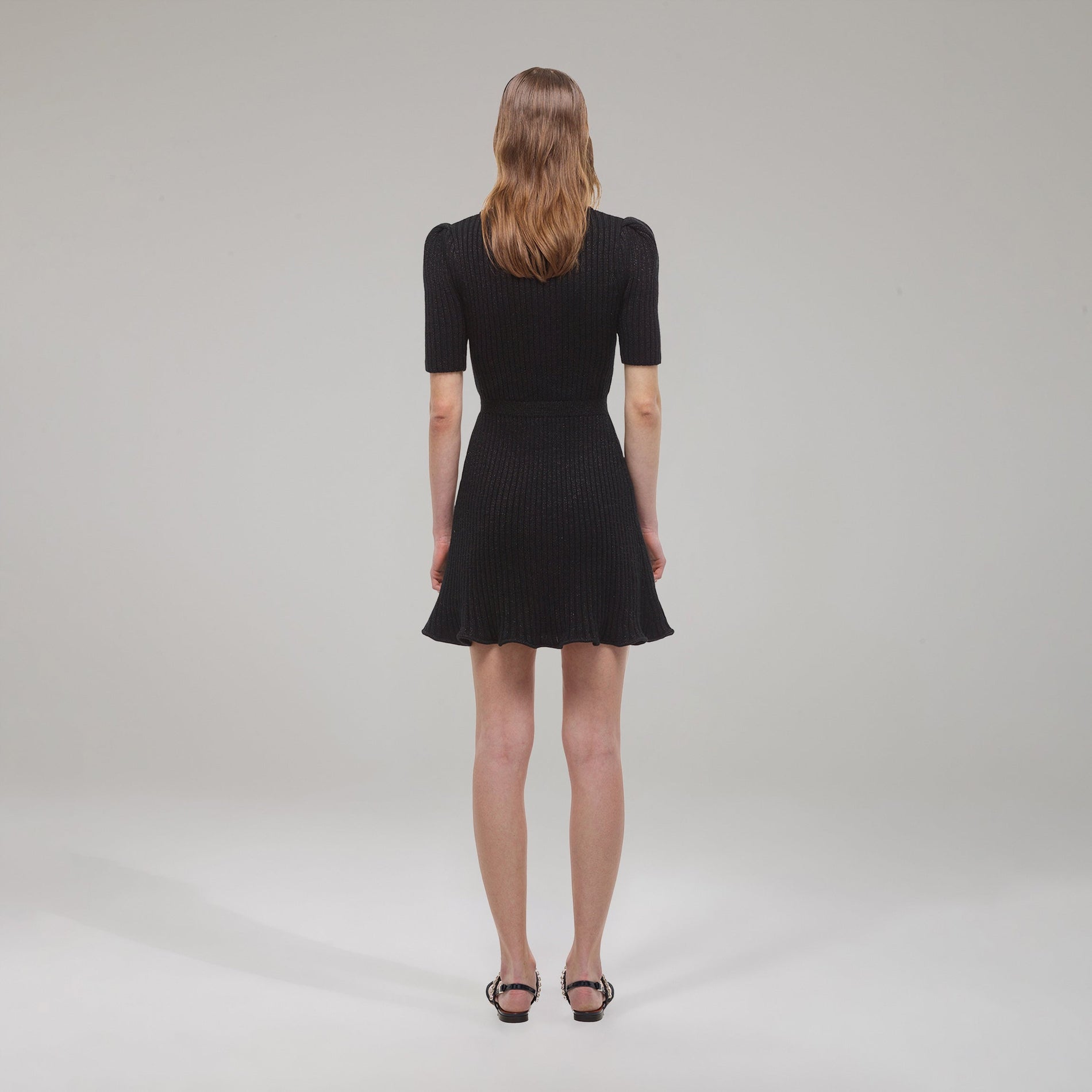 A woman wearing the Black Lurex Contrast Trim Mini Dress