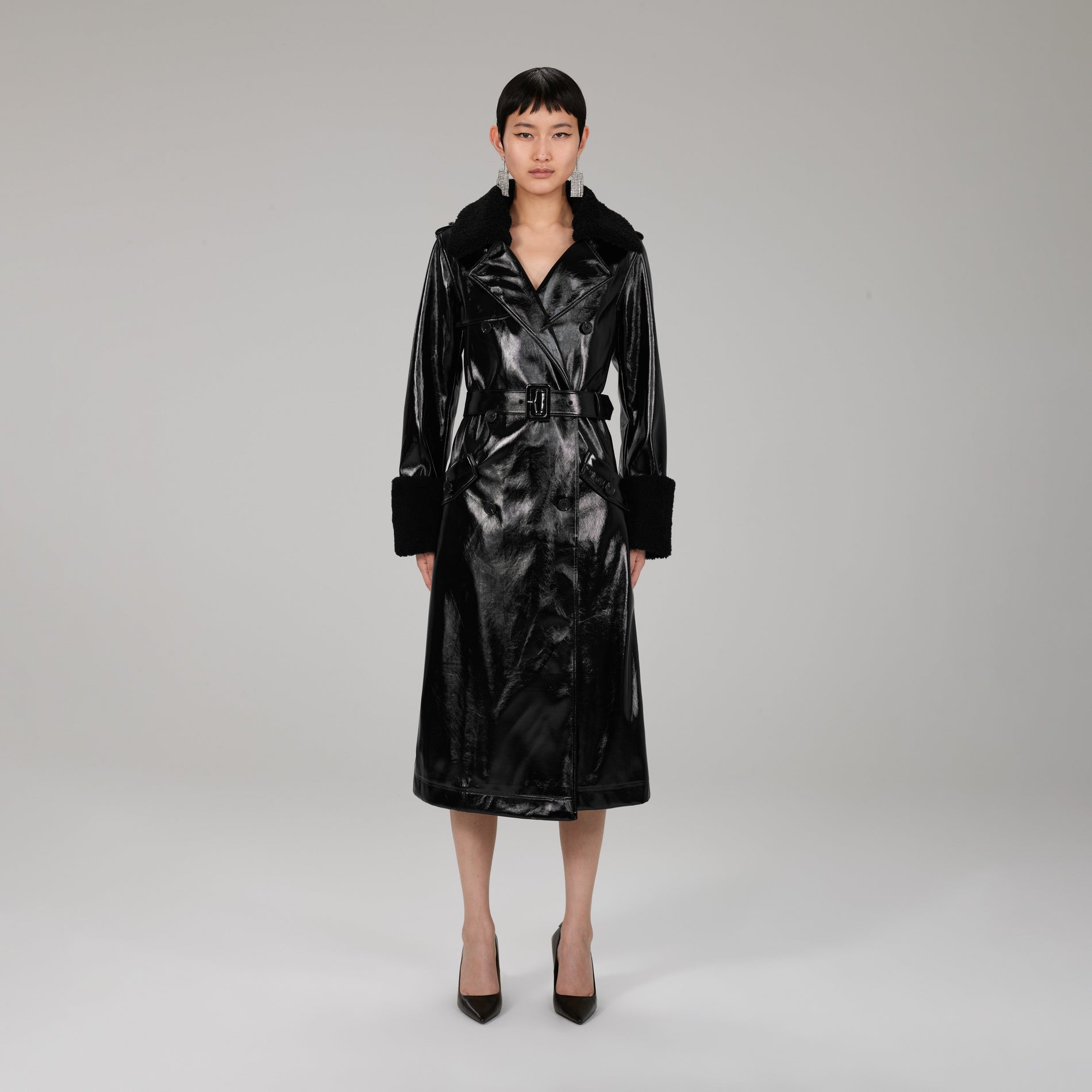 A woman wearing the Black Patent Coat