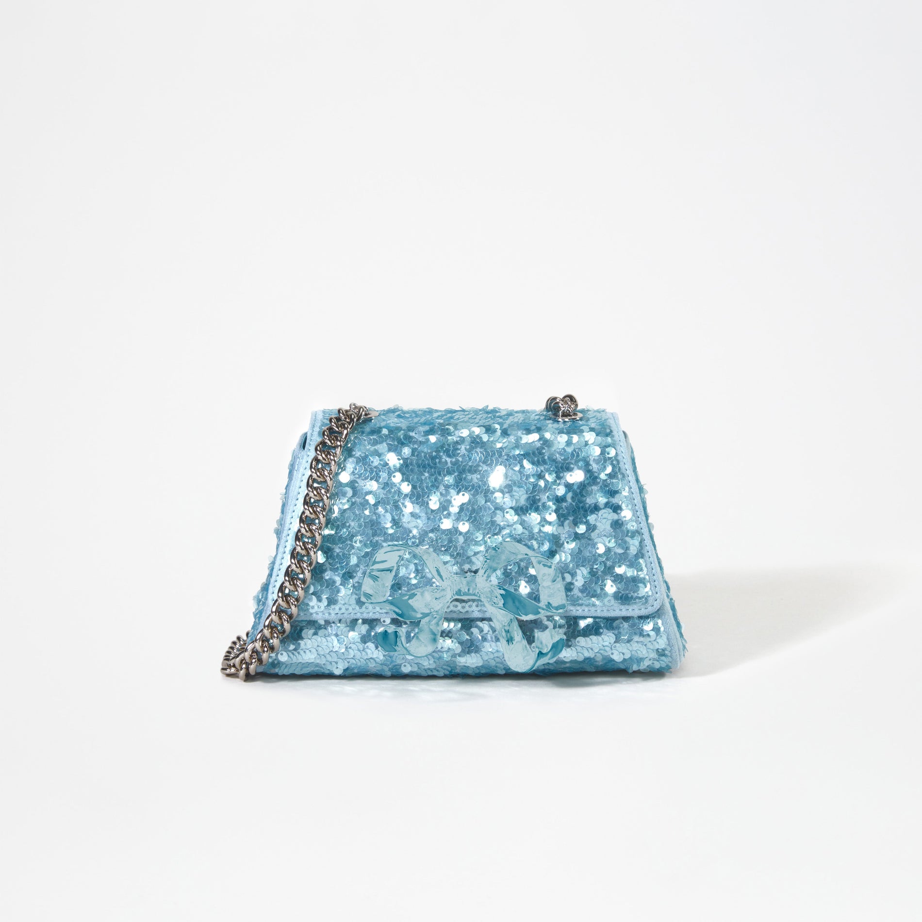 A woman wearing the Blue Sequin Bow Mini Shoulder Bag