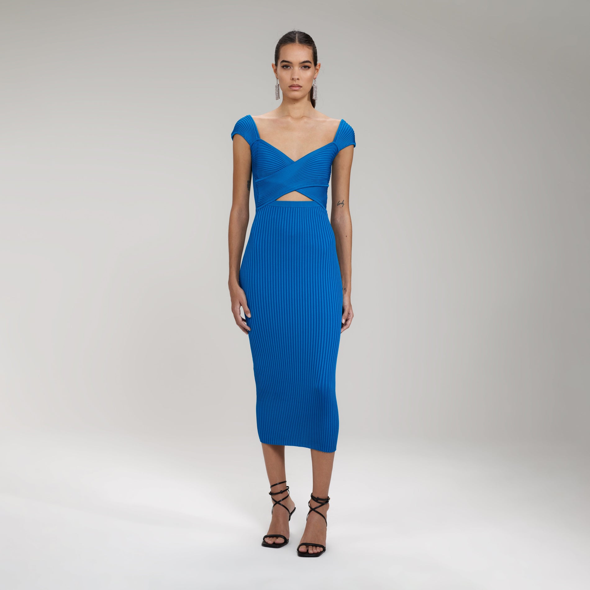 A woman wearing the Bright Blue Ribbed Knit Crossover Bust Midi Dress