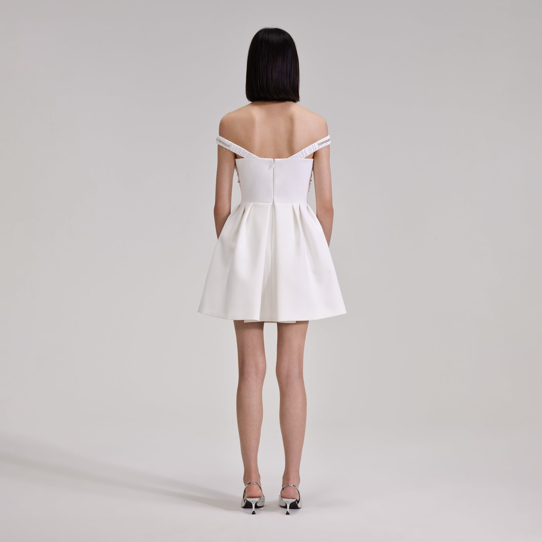 A woman wearing the White Diamante Bust Mini Dress
