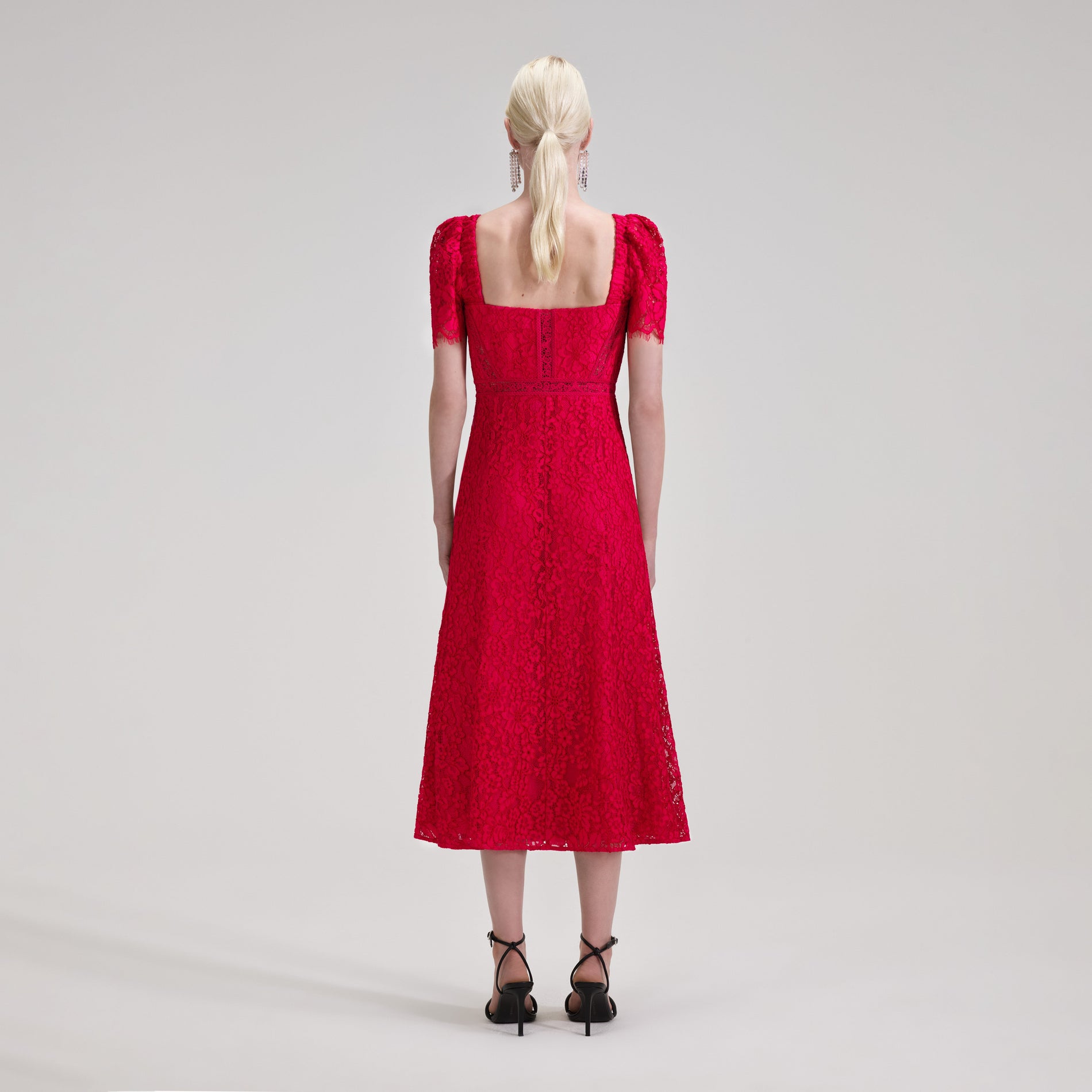 A woman wearing the Red Lace Midi Dress