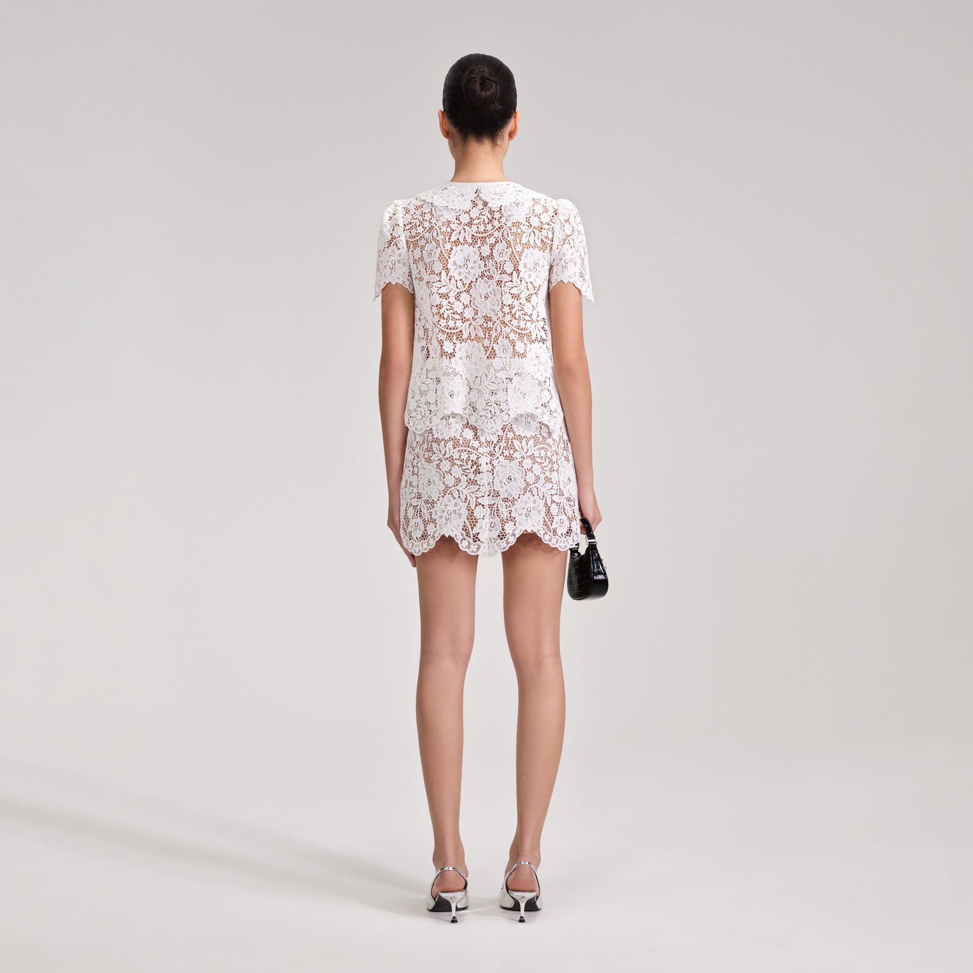 A woman wearing the White Cord Lace Mini Skirt