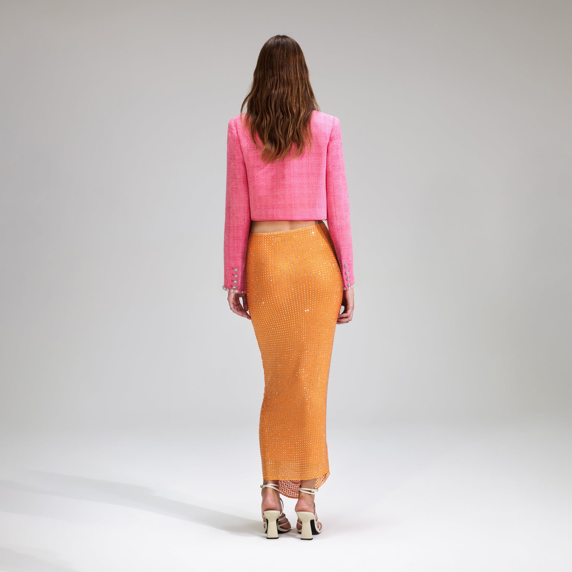 A woman wearing the Orange Rhinestone Mesh Midi Skirt