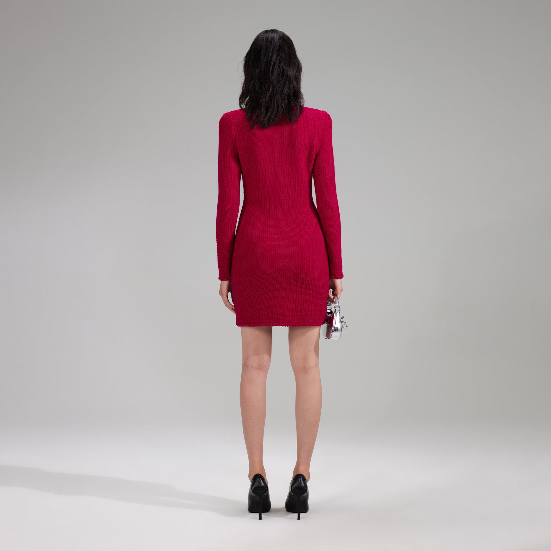 A woman wearing the Red Melange Knit Mini Bow Dress