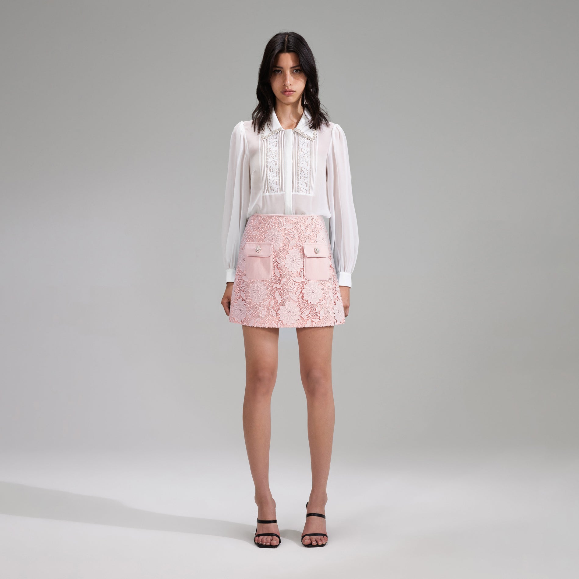 A woman wearing the Pink Guipure Lace Mini Skirt