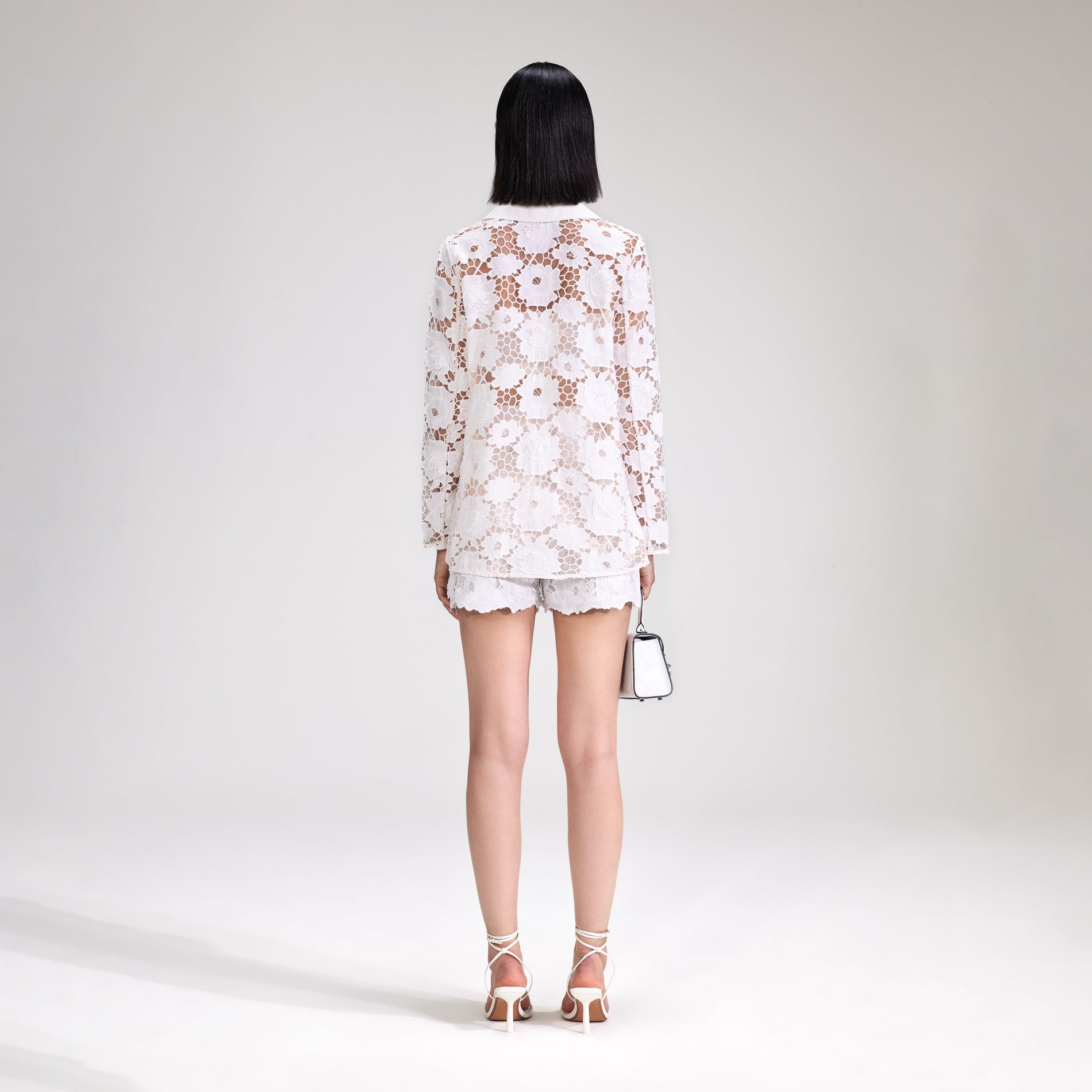 A woman wearing the White 3D Cotton Lace Shorts