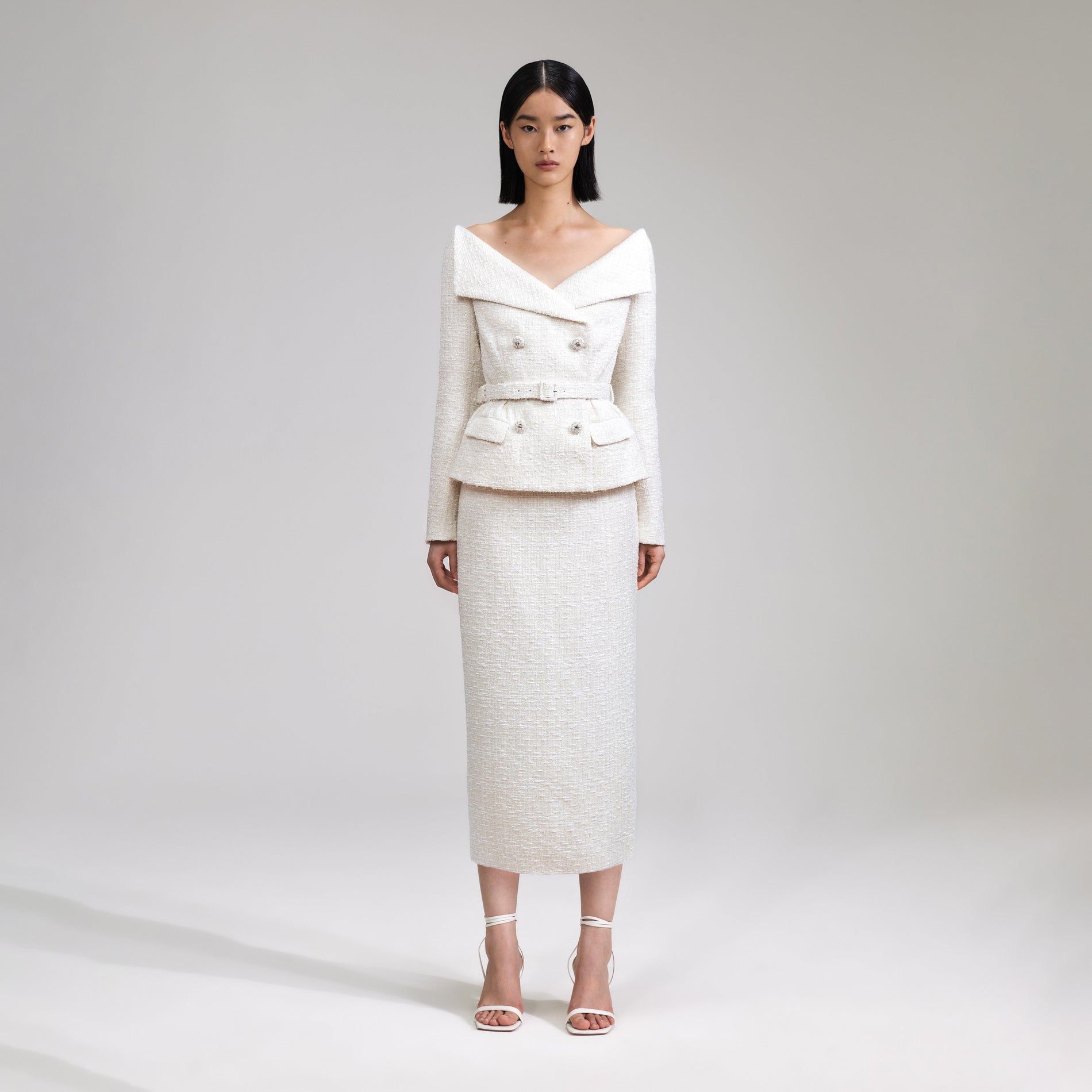 A woman wearing the Cream Off Shoulder Boucle Midi Dress